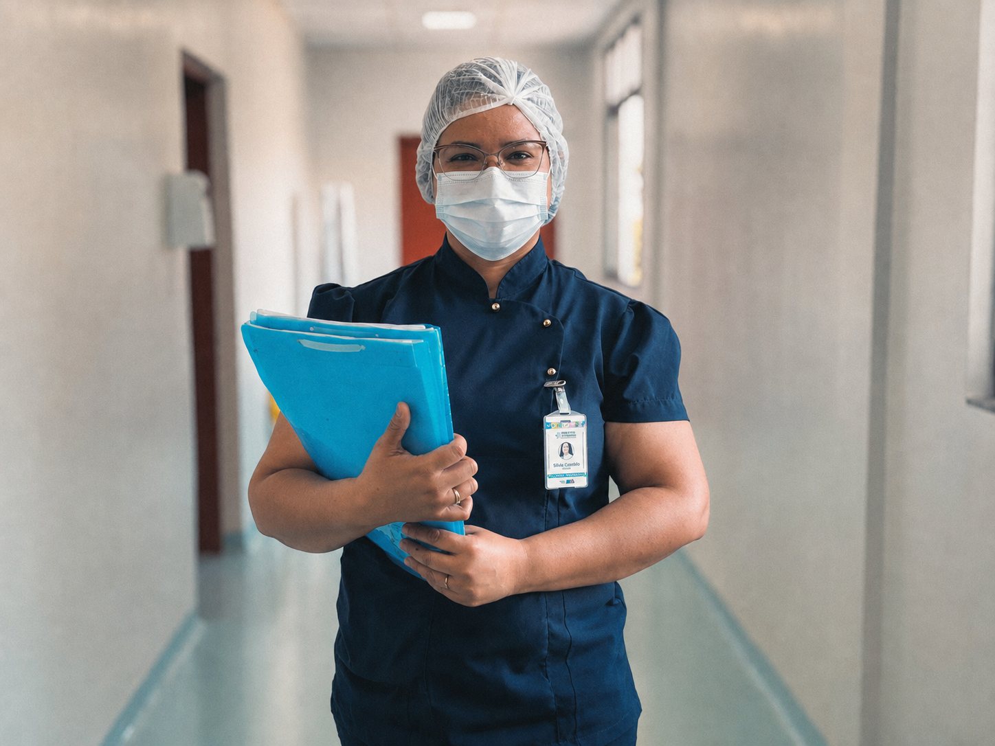 Profissional de saúde com prontuários no corredor do hospital